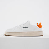 Jägermeister x Flowers For Society The Curt Sneaker i vitt läder, sidovy mot vit bakgrund med orange mockahällapp och Jägermeister-logga på sidan