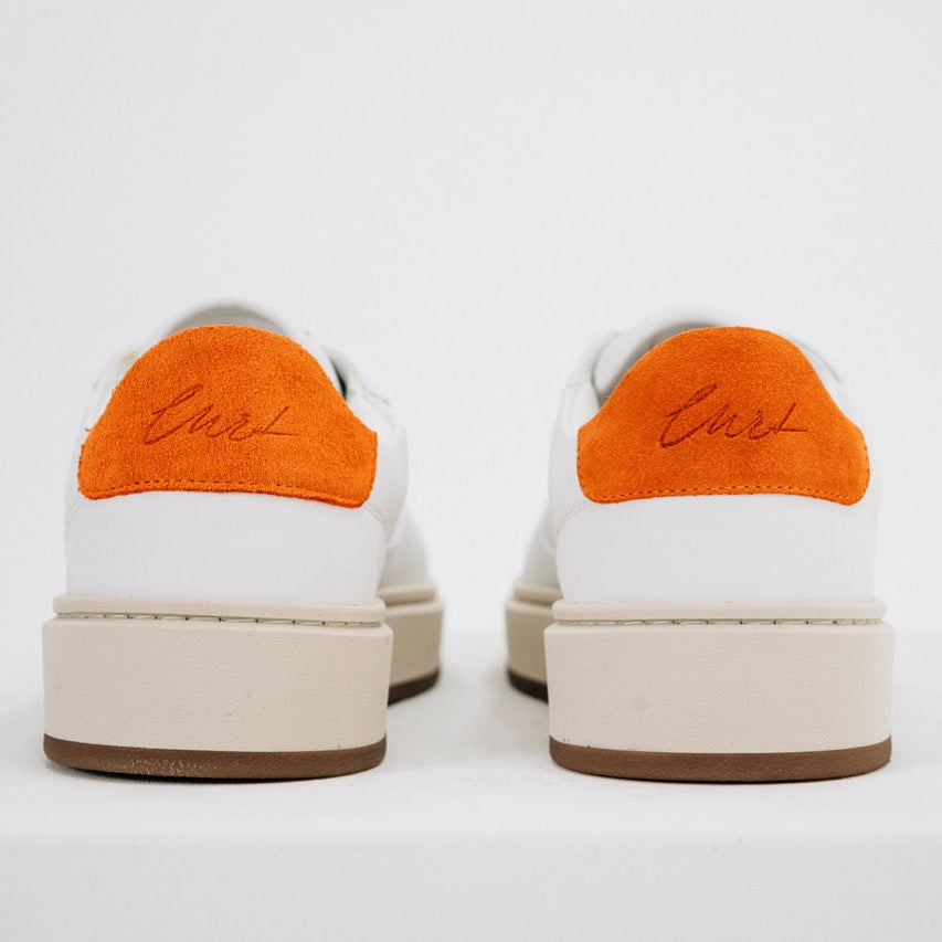 Jägermeister x Flowers For Society The Curt Sneaker vit, bakifrån med orange mockahällapp och graverad "Curt"-signatur