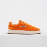 Jägermeister x Flowers For Society The Curt Sneaker i orange mocka, sidovy mot vit bakgrund med Jägermeister-logga på sidan